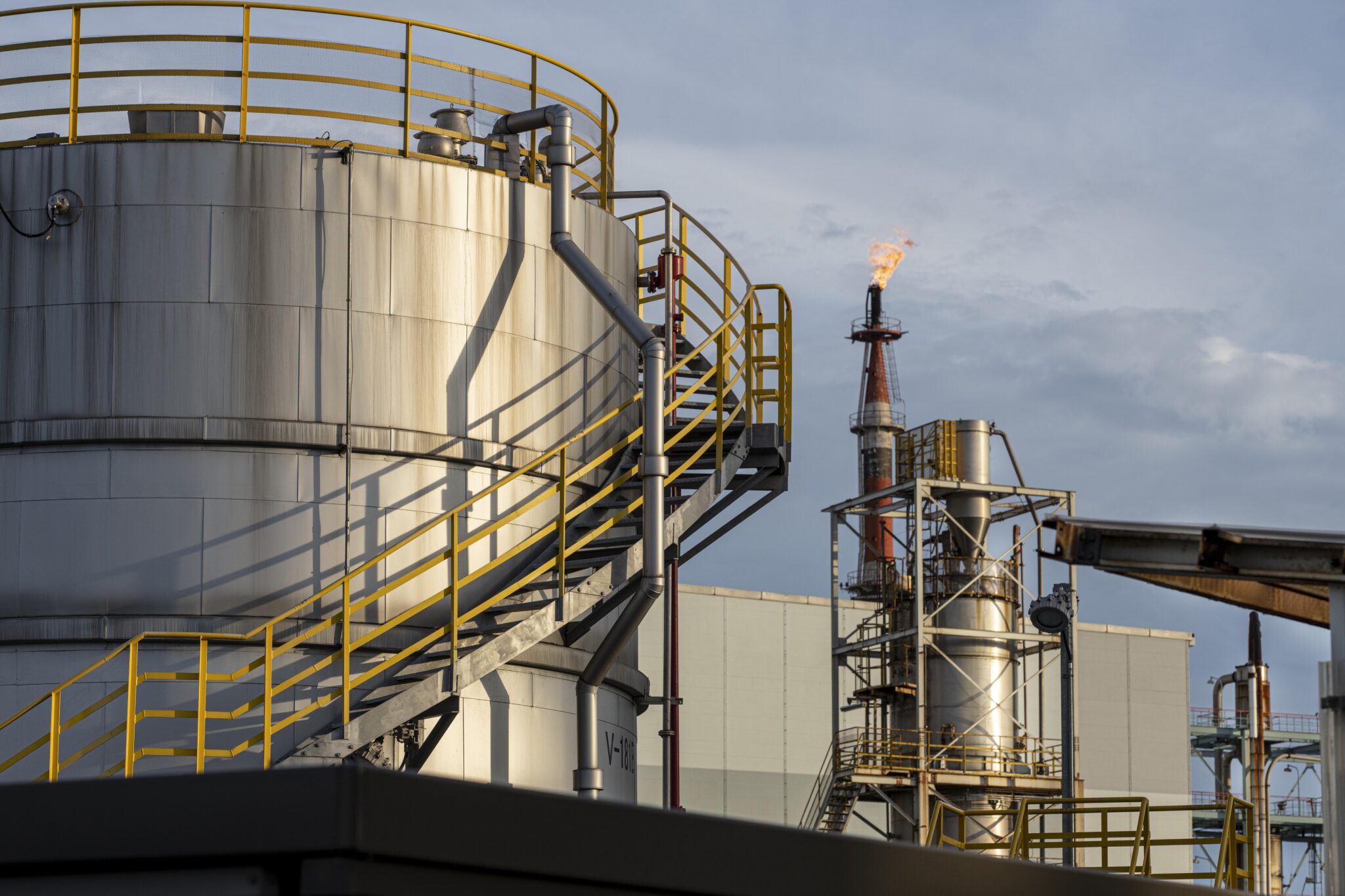 A gas tank and tower on top of an industrial plant.